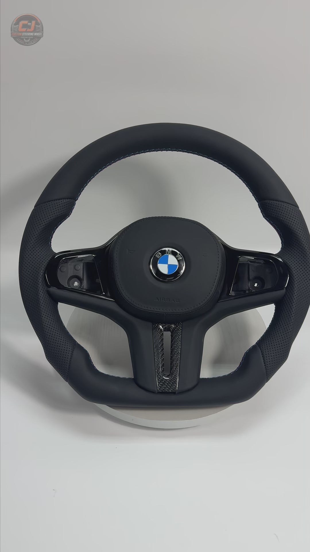 White background showcase video of BMW custom leather sport steering wheel with perforated handles, smooth leather finish and carbon trim for BMW G02 G05 G06 G09 G11 G12 G15 G20 G22 G28 G29 G30 G38 G80 G82 F40 F90 by CJ Mod Garage
