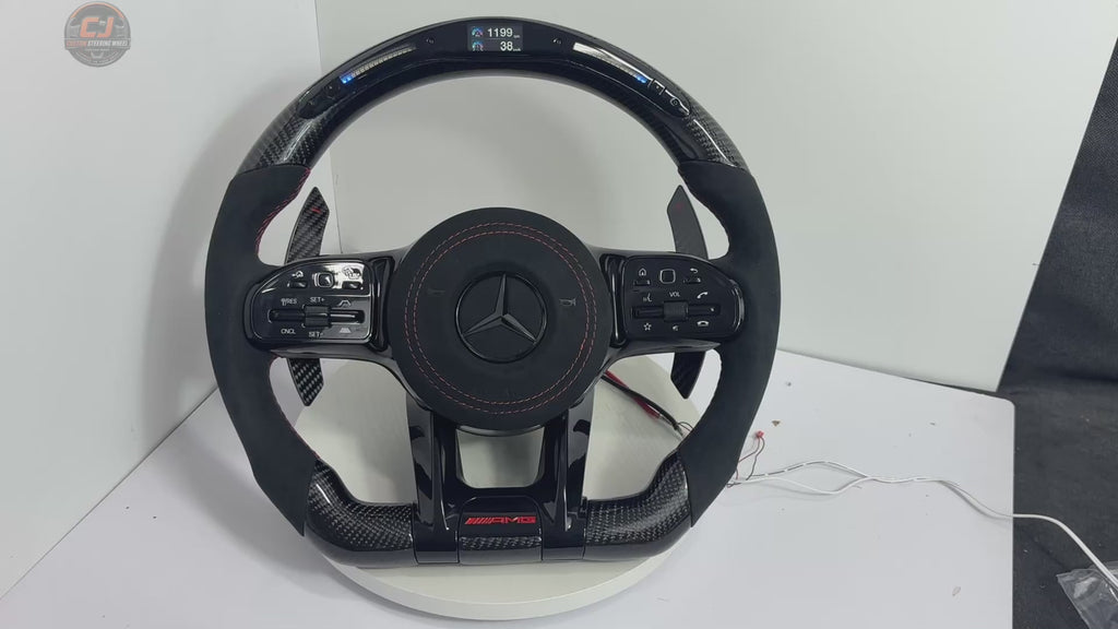 White background video of Mercedes AMG custom steering wheel with forged carbon finish, LED shift lights, Alcantara grip and paddle shifters for W117 W176 W177 W203 W204 W205 W211 W212 W213 W218 C43 C63 C200 C300 by CJ Mod Garage