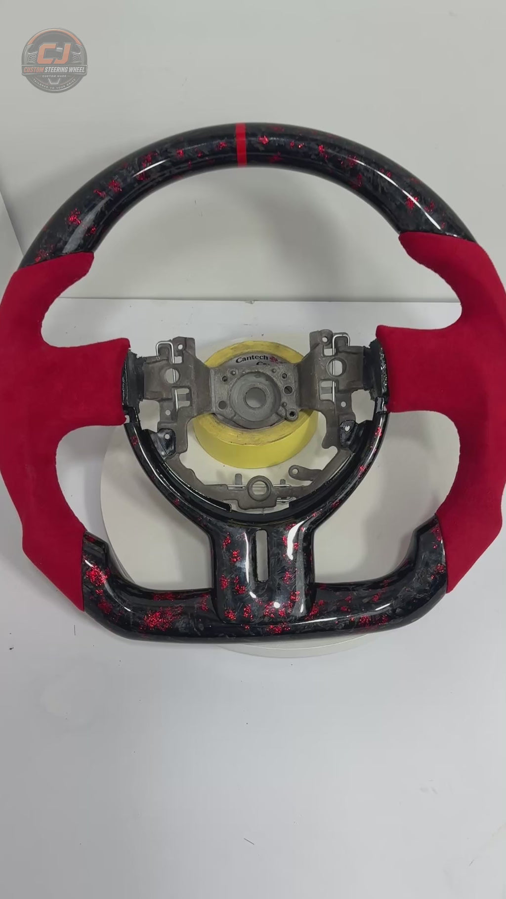 360-degree product video of Toyota GT86 forged carbon fiber steering wheel with red flake finish, red Alcantara grip sections, flat-bottom design and custom motorsport styling by CJ Mod Garage