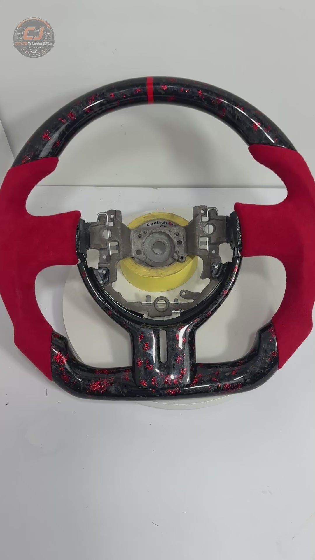 360-degree product video of Toyota GT86 forged carbon fiber steering wheel with red flake finish, red Alcantara grip sections, flat-bottom design and custom motorsport styling by CJ Mod Garage