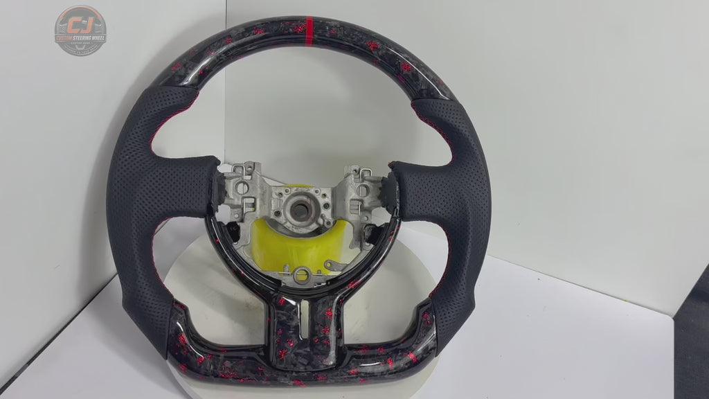 360-degree studio video of Toyota GT86 forged carbon fiber steering wheel with red flake finish, perforated leather grips, red stitching and flat-bottom motorsport styling by CJ Mod Garage