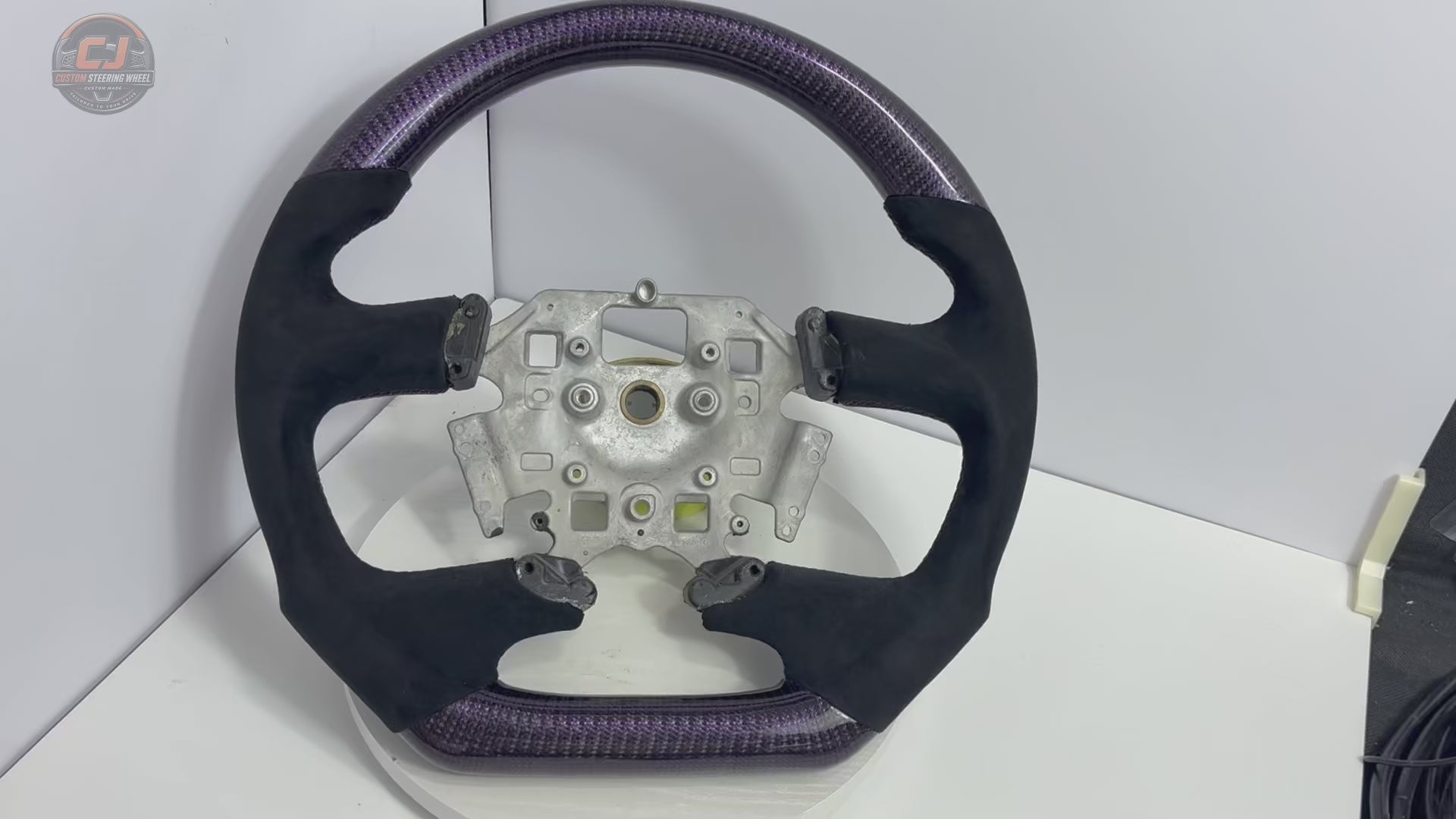 White background product video of Ford Falcon FG XR XR6 XR8 custom steering wheel in purple carbon fiber and black suede grips by CJ Mod Garage