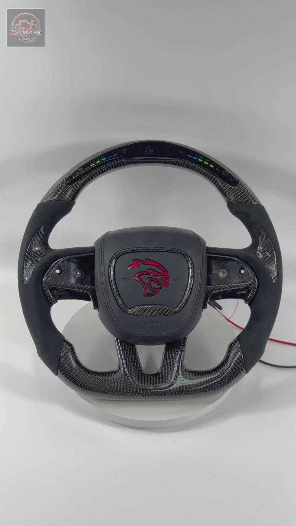 Custom Dodge Charger Challenger Hellcat carbon fiber LED steering wheel video featuring integrated RGB shift lights, Alcantara grips, and performance-inspired design on white background