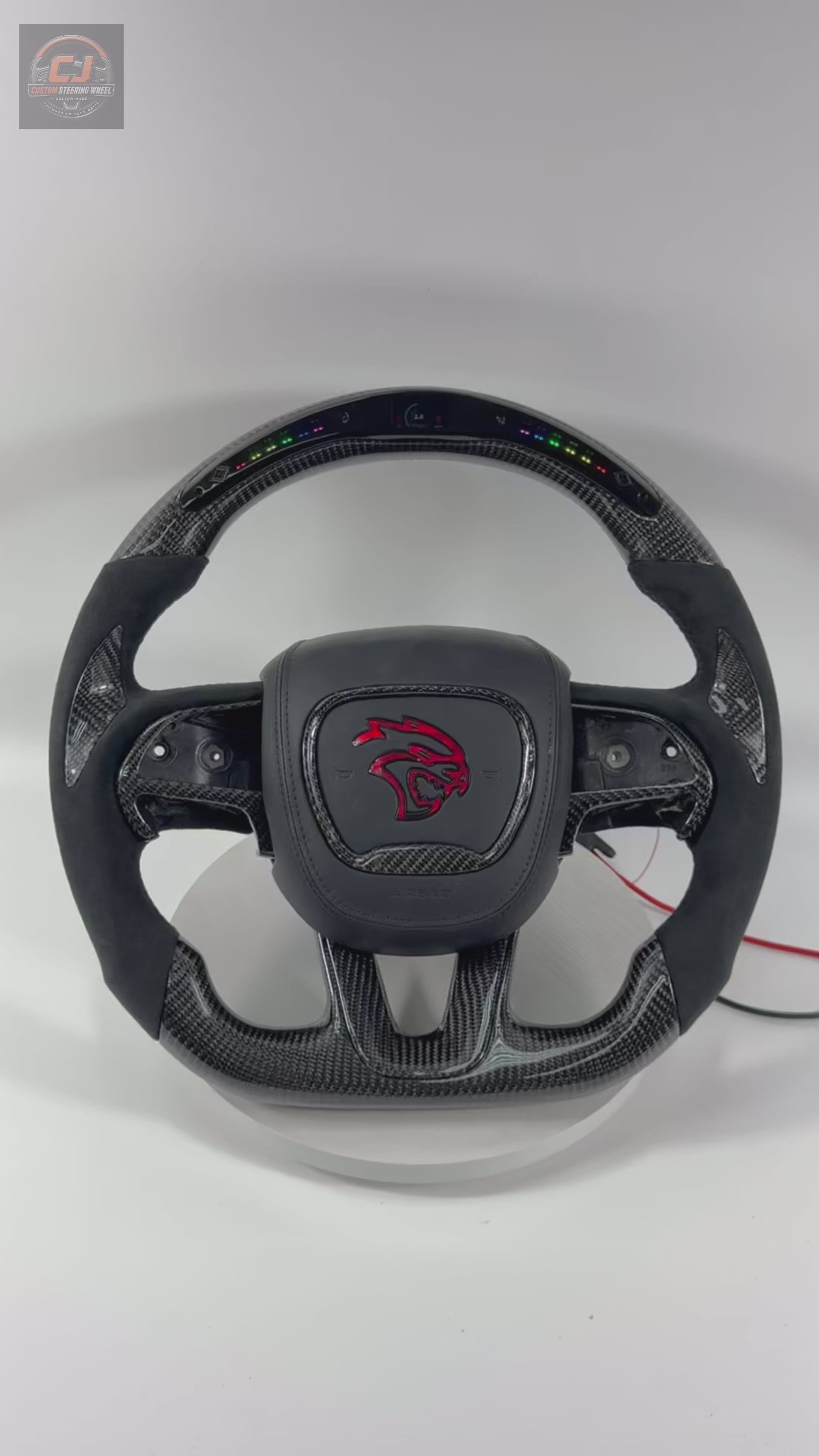 Custom Dodge Charger Challenger Hellcat carbon fiber LED steering wheel video featuring integrated RGB shift lights, Alcantara grips, and performance-inspired design on white background