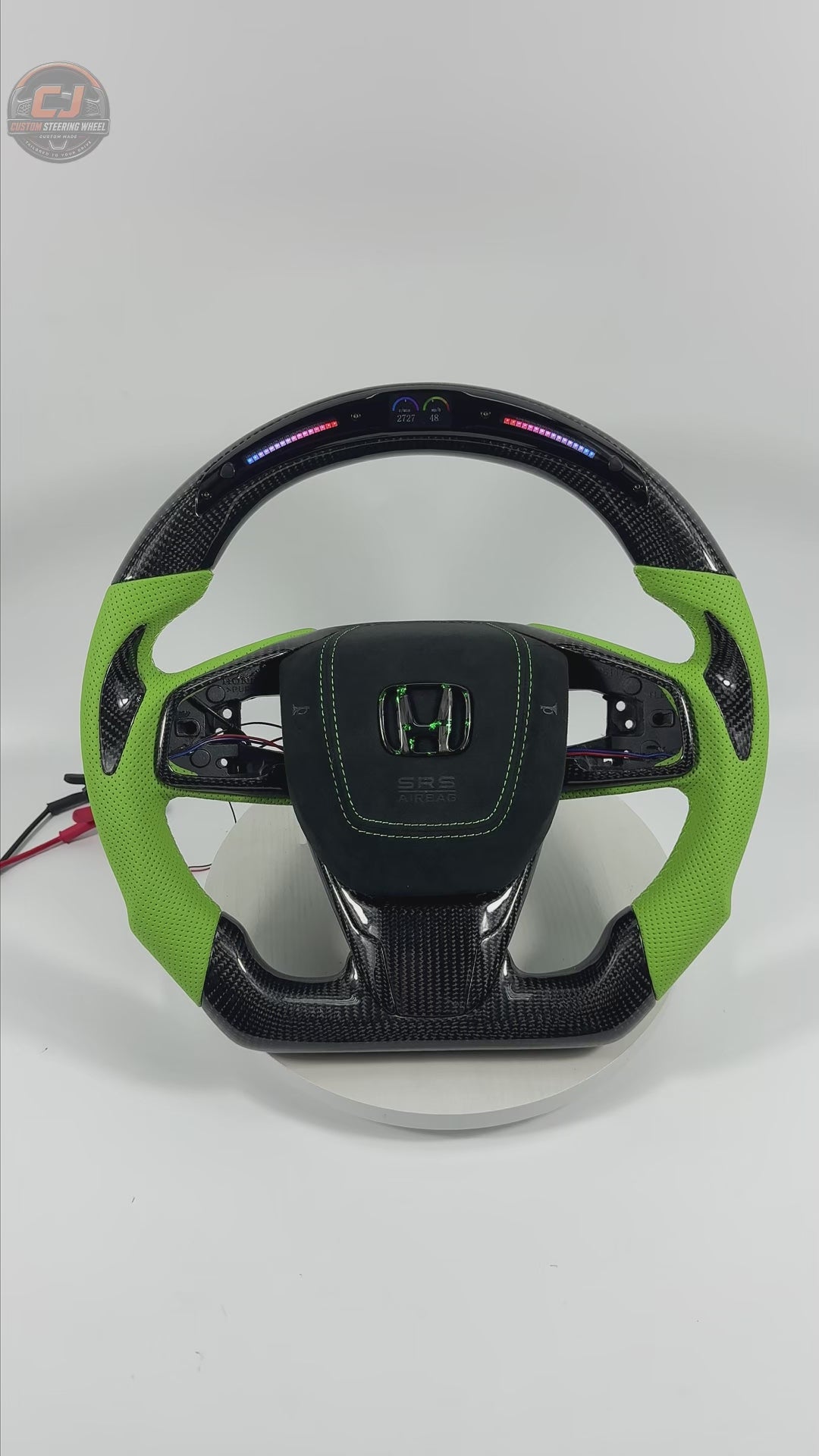 Honda Civic FK8 carbon fiber steering wheel rotating on white background with lime green perforated leather grips LED shift light display and airbag cover by CJ Mod Garage