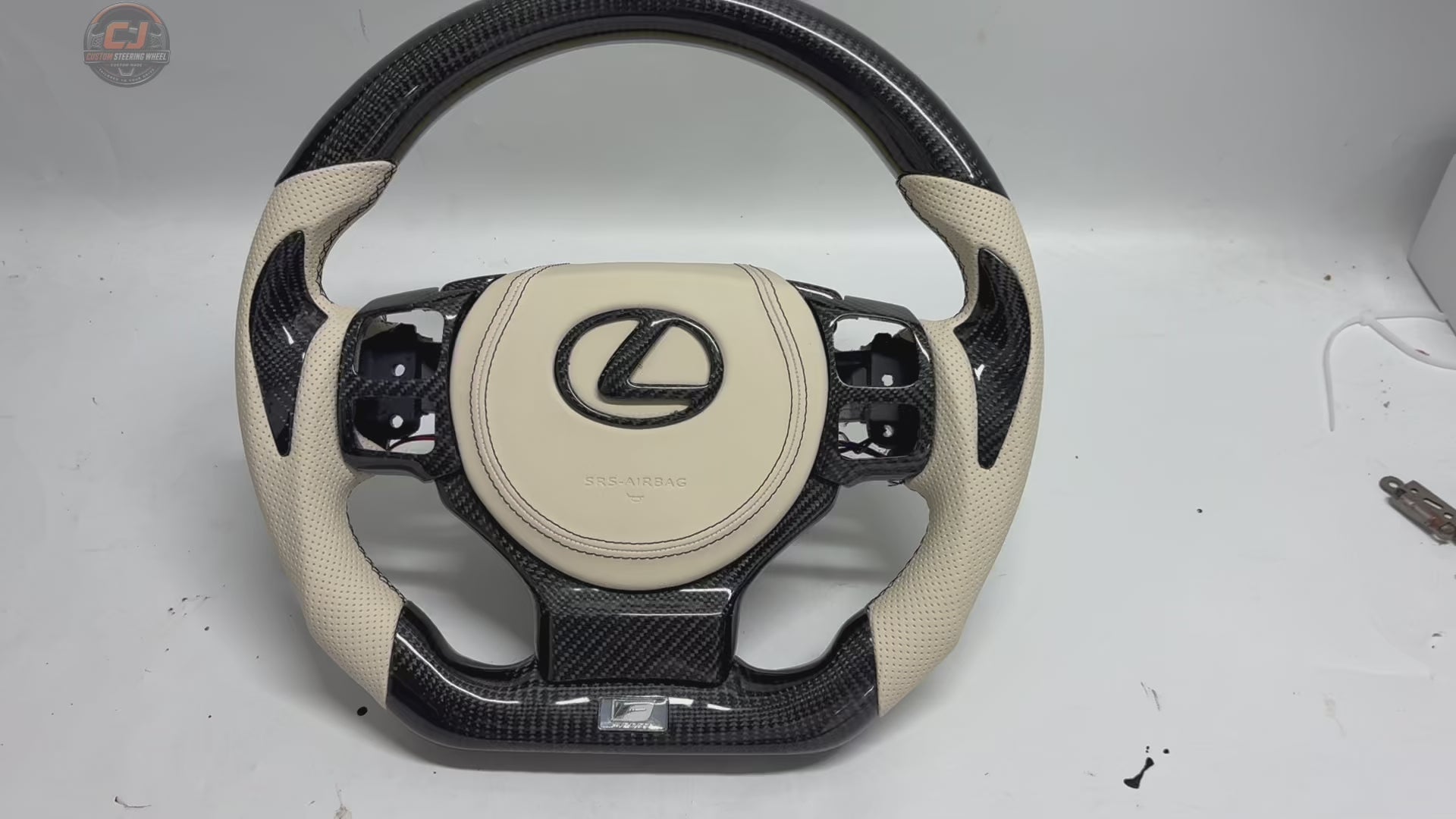 Lexus Custom Steering Wheel Product Video Highlighting Carbon Fiber Weave White Leather Airbag Cover Flat Bottom Shape And Detailed Finish For Lexus IS 2014 2020 RC 2015 2020 GS 2013 2020 NX 2015 2021 CT 2014 2022 CJ Mod Garage