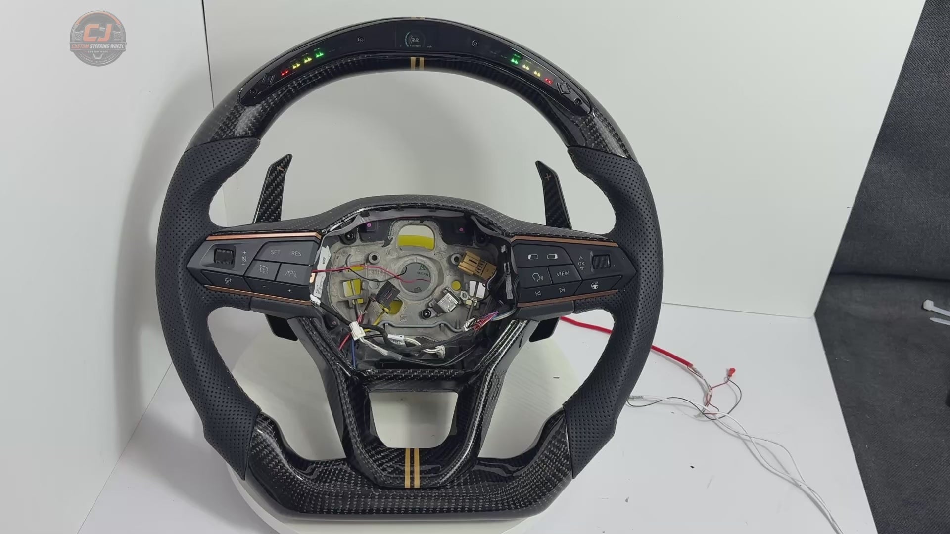 Showcase video of Seat Leon MK4 carbon fiber steering wheel highlighting LED shift light display perforated leather grip multifunction buttons paddle shifters and custom craftsmanship by CJ Mod Garage