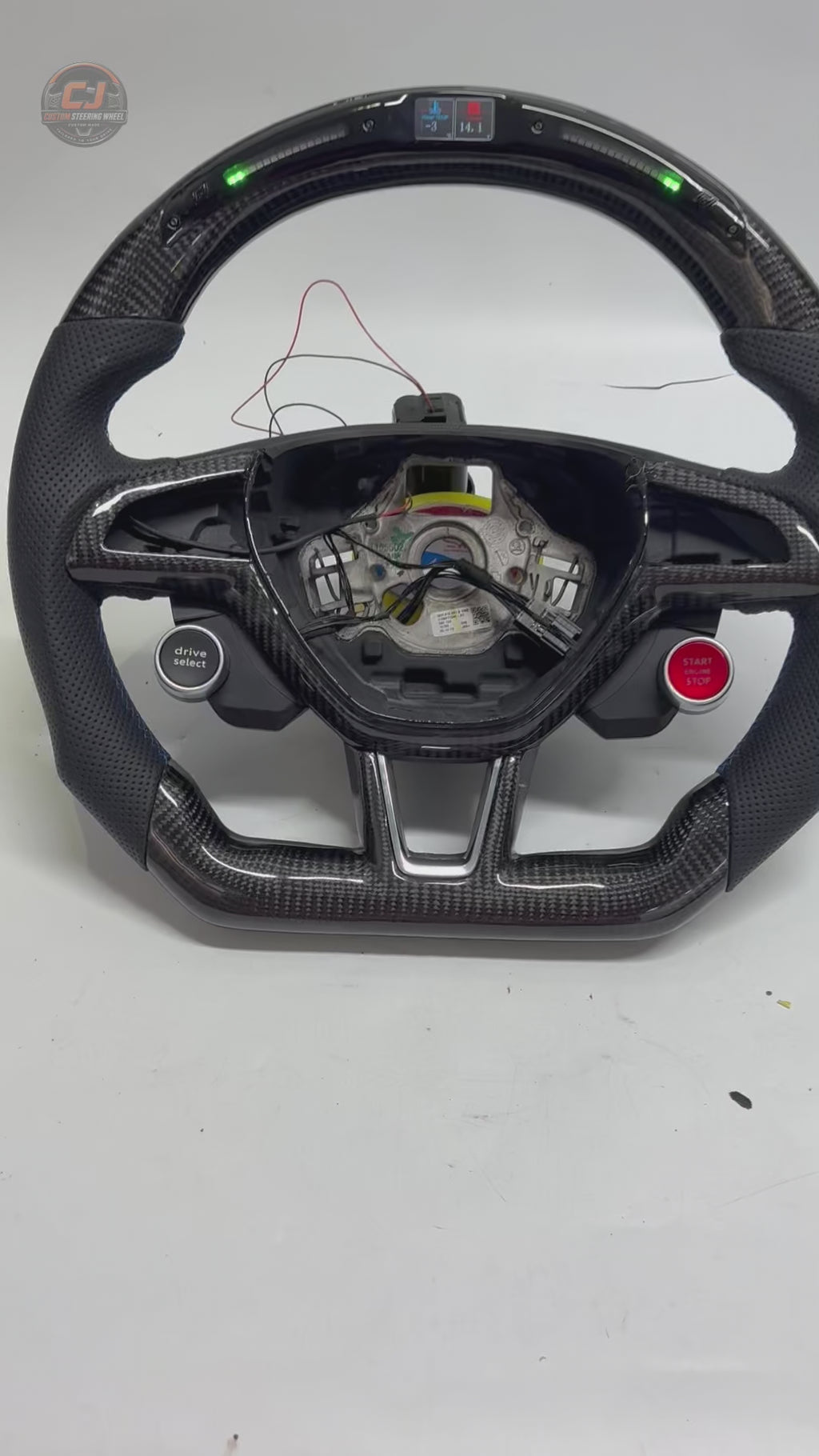 Studio showcase of custom Skoda steering wheel with LED display carbon fiber construction perforated leather grip drive select and start stop controls for Octavia MK3 vRS 2014 2020 Superb 3V 2015 2023 Kodiaq 2017 2024 by CJ Mod Garage