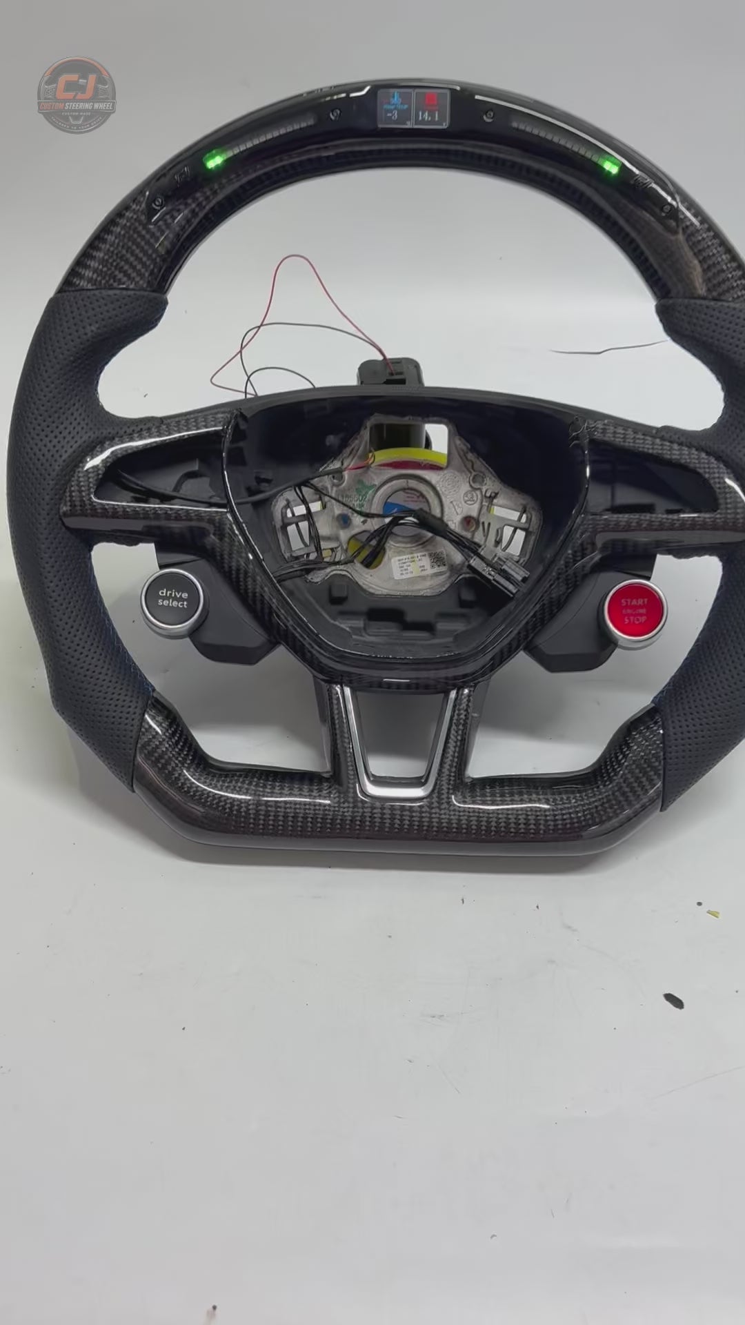 Studio showcase of custom Skoda steering wheel with LED display carbon fiber construction perforated leather grip drive select and start stop controls for Octavia MK3 vRS 2014 2020 Superb 3V 2015 2023 Kodiaq 2017 2024 by CJ Mod Garage