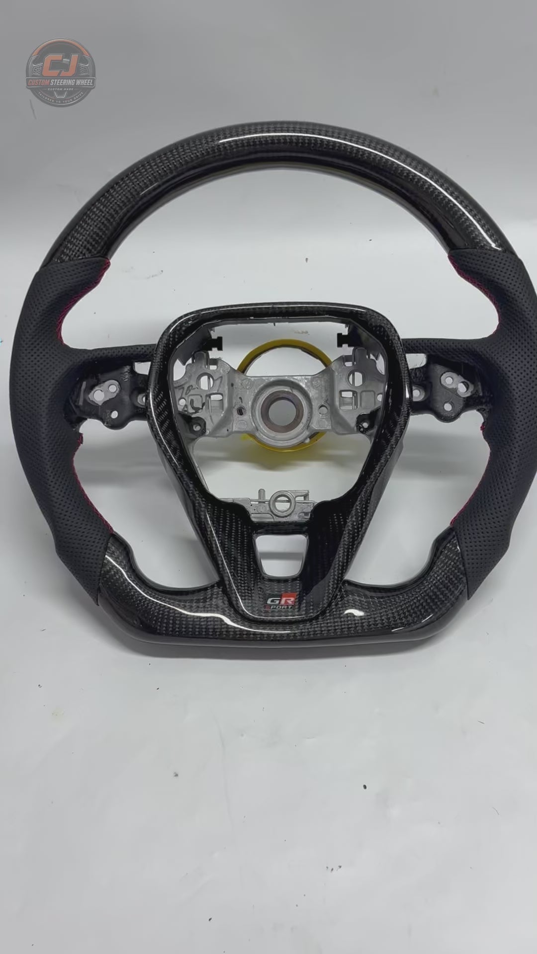 360-degree studio video of Toyota Corolla Altis Levin GR Corolla carbon fiber steering wheel with perforated leather grips, red contrast stitching and flat-bottom sport design by CJ Mod Garage