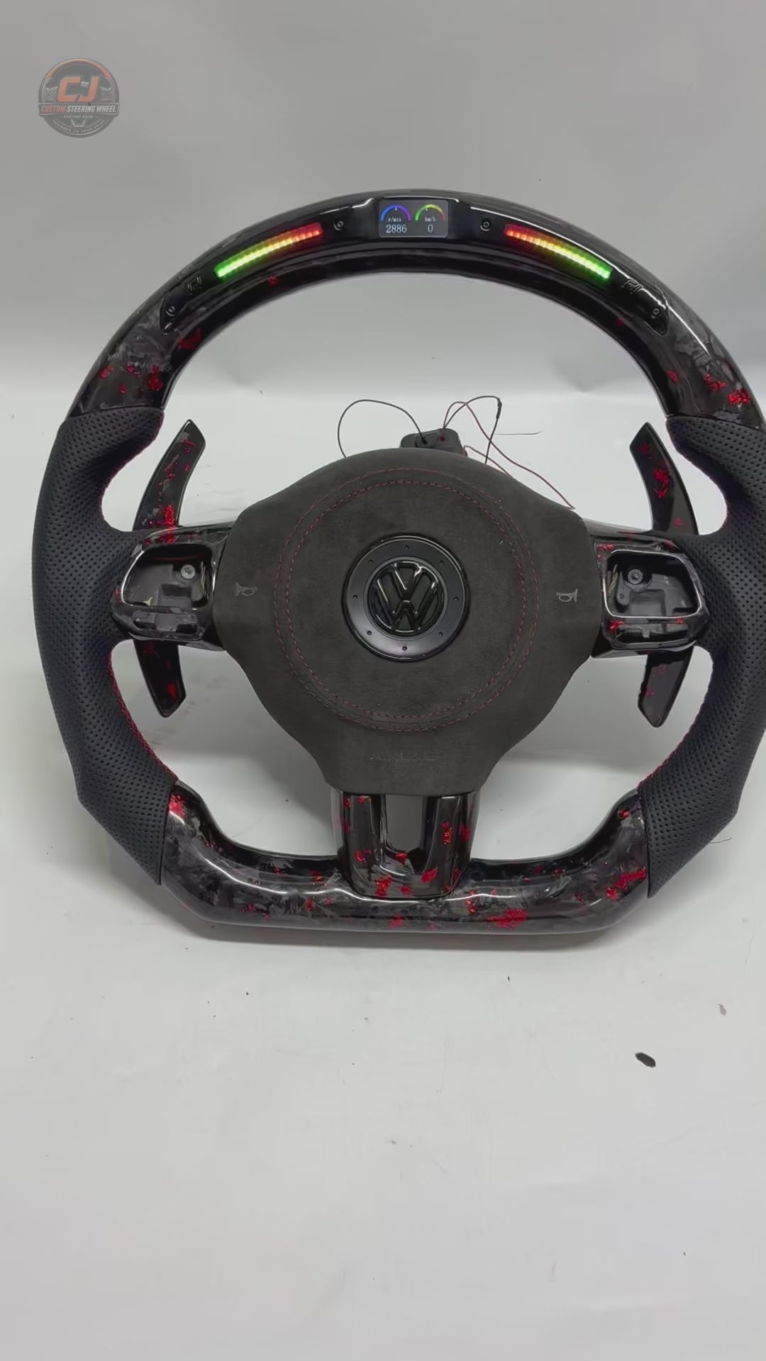 Rotating product video showing forged carbon red flake steering wheel with LED shift light display paddle shifters and perforated leather grips for Golf 6 MK6 Polo GTD MK7 R Line CC Jetta by CJ Mod Garage