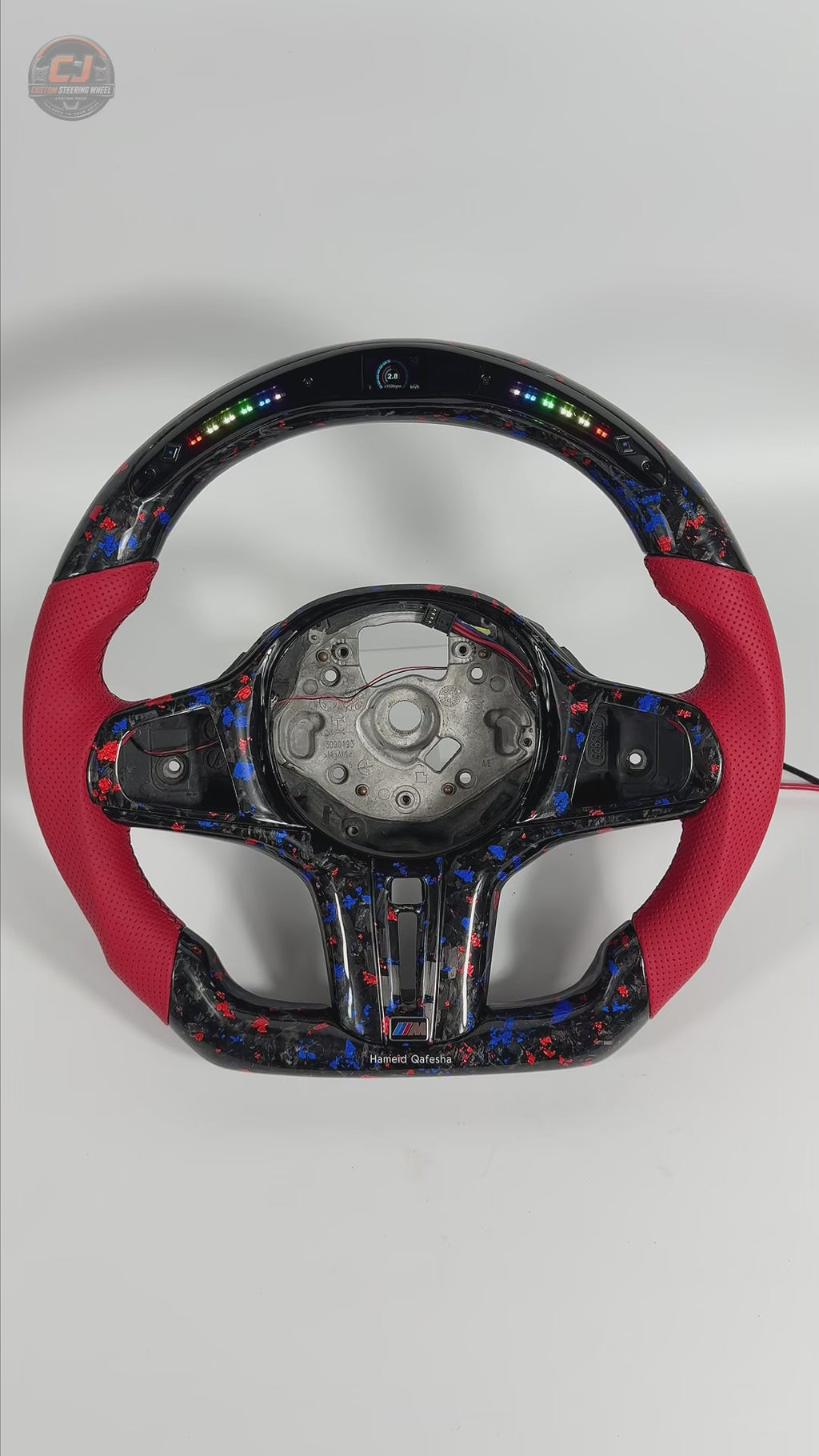 White background product video featuring BMW forged carbon steering wheel with red leather grips, RGB LED shift indicator and custom airbag cover for BMW G02 G05 G06 G09 G11 G12 G15 G20 G22 G28 G29 G30 G38 G80 G82 F40 F90 by CJ Mod Garage