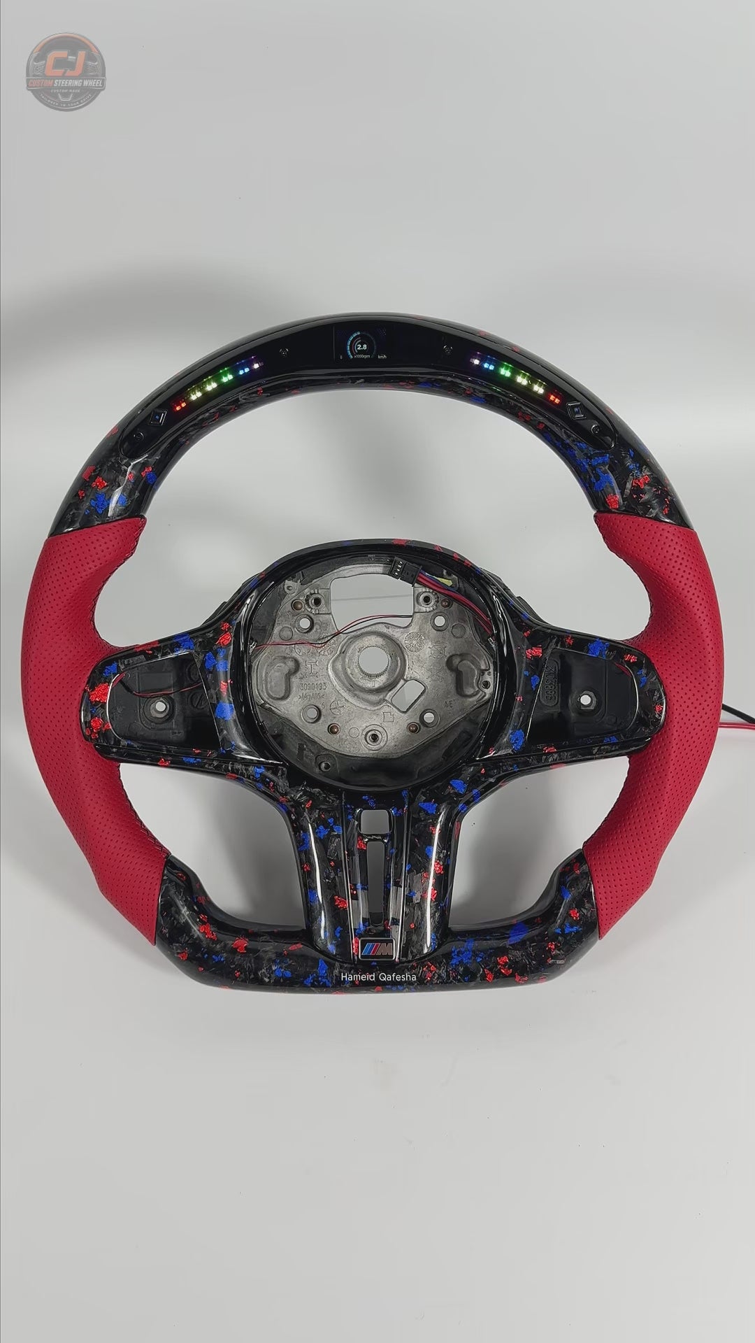 White background product video featuring BMW forged carbon steering wheel with red leather grips, RGB LED shift indicator and custom airbag cover for BMW G02 G05 G06 G09 G11 G12 G15 G20 G22 G28 G29 G30 G38 G80 G82 F40 F90 by CJ Mod Garage