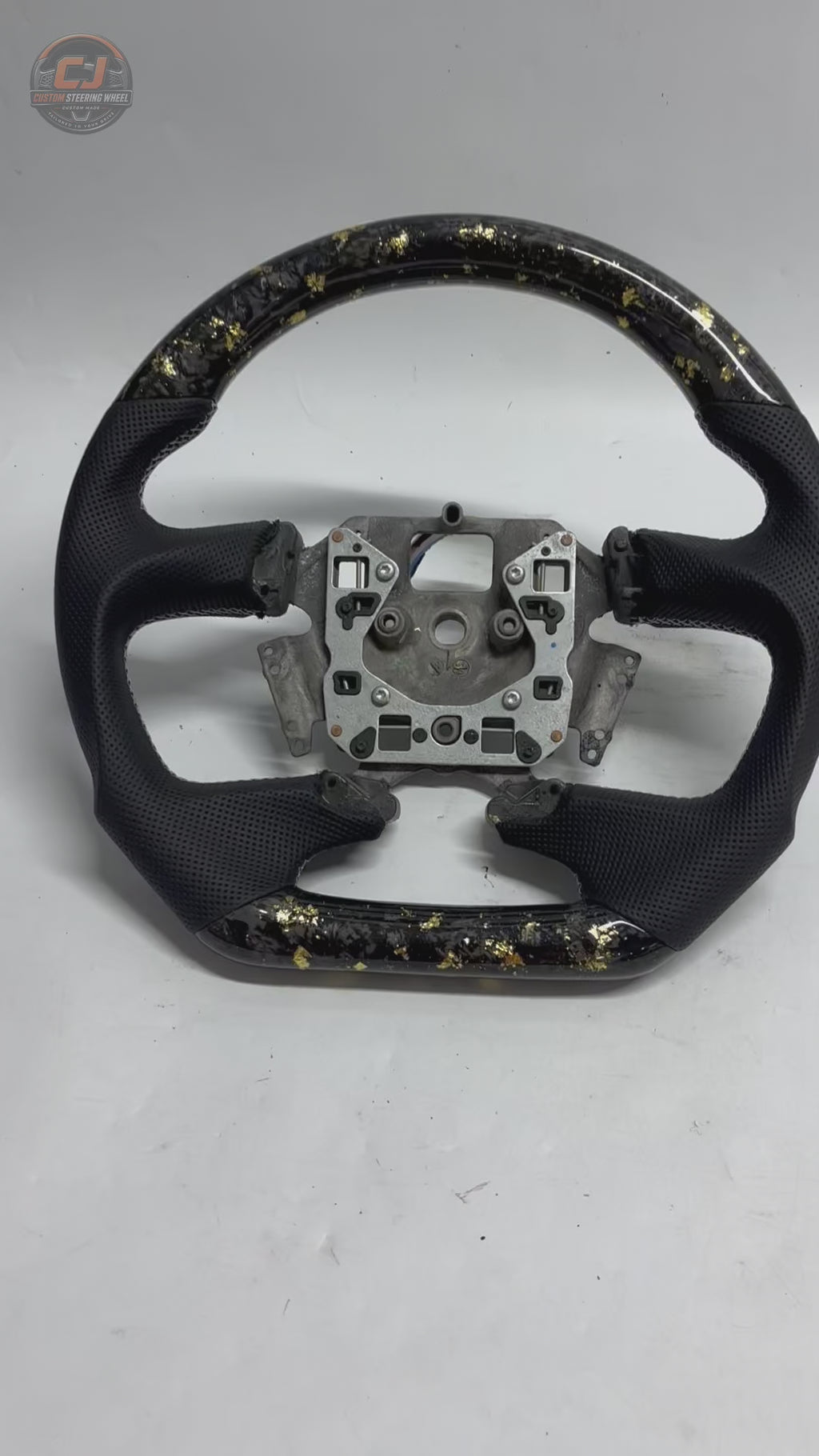 White background product video of Ford Falcon FG XR XR6 XR8 custom steering wheel in gold flake forged carbon and black perforated leather by CJ Mod Garage