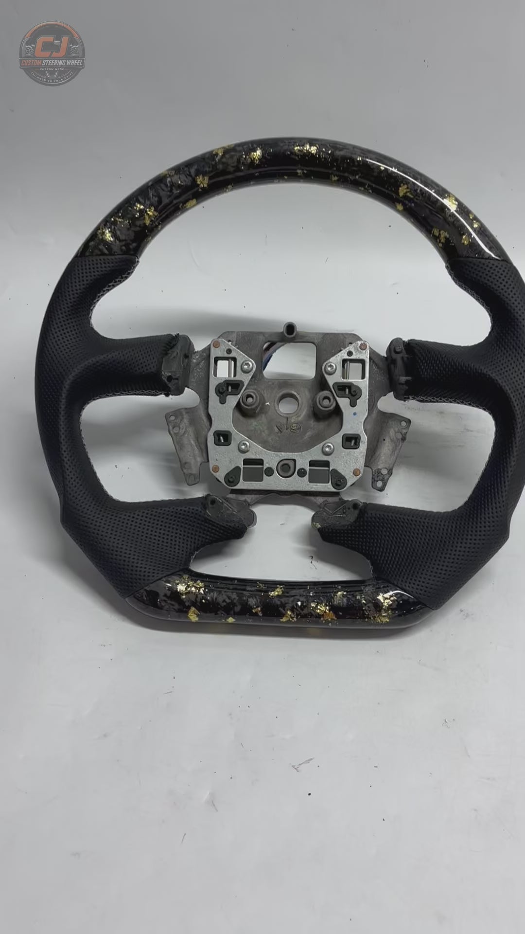 White background product video of Ford Falcon FG XR XR6 XR8 custom steering wheel in gold flake forged carbon and black perforated leather by CJ Mod Garage