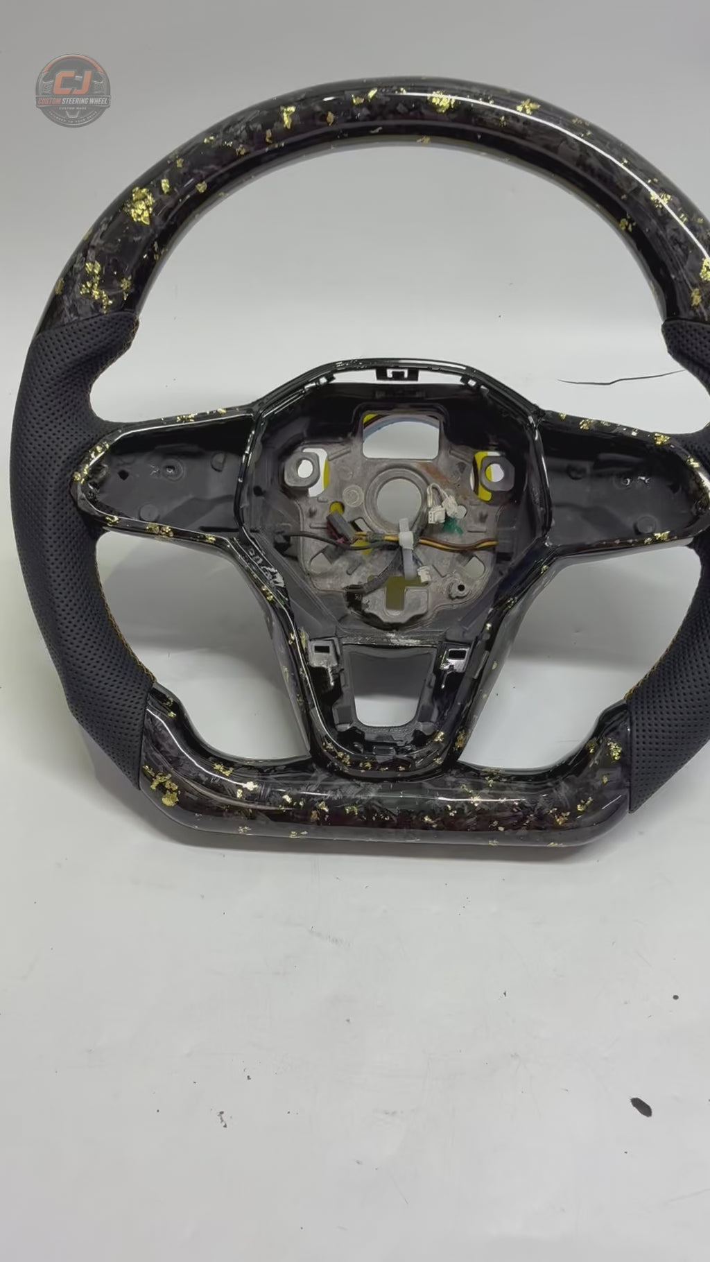 Studio rotation video showcasing forged carbon steering wheel with gold flake detailing premium leather grips and performance inspired design for Golf 8 MK8 Passat Touareg Tiguan Polo GTD MK7 MK6 R Line CC Jetta by CJ Mod Garage