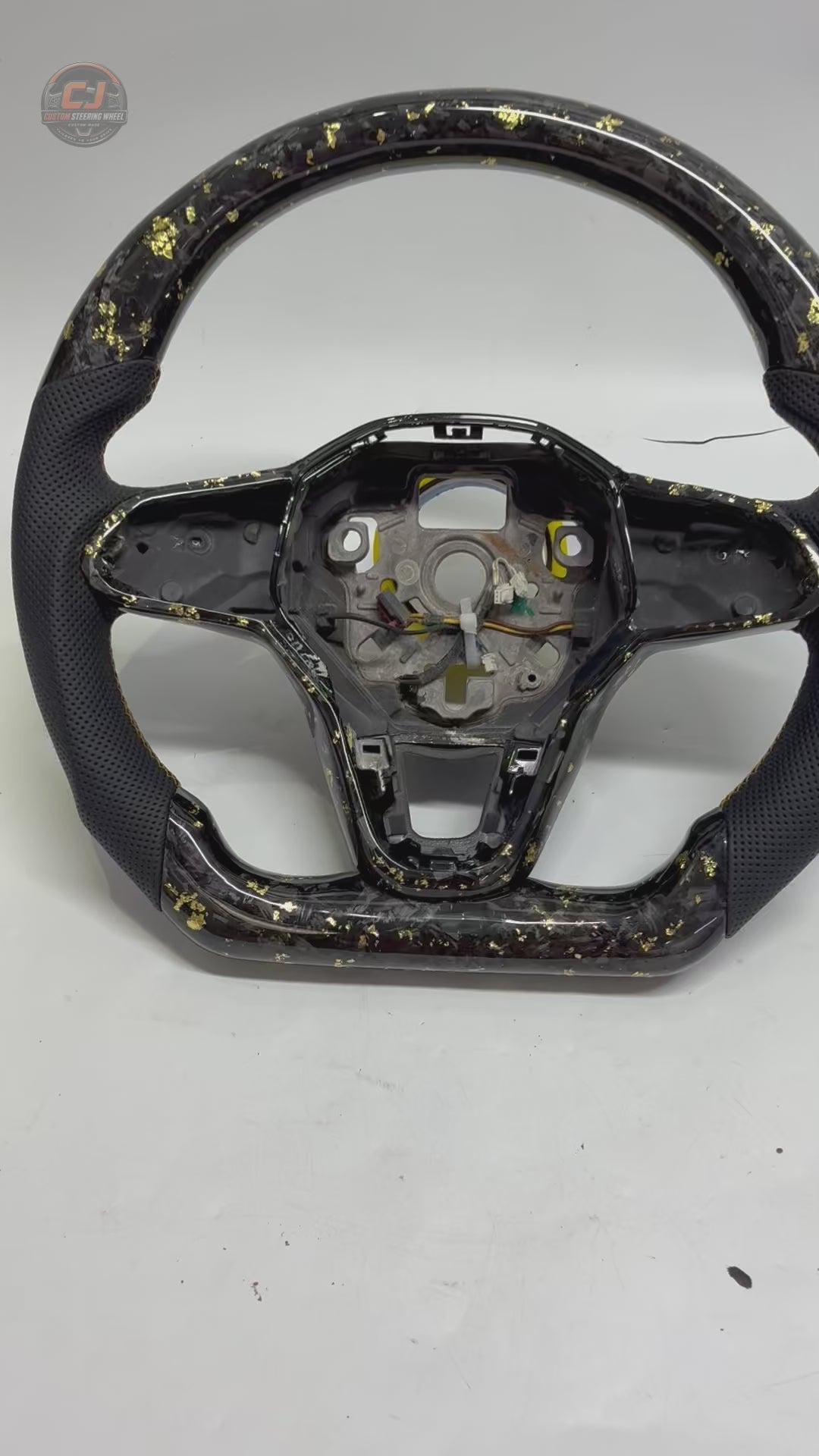 Studio rotation video showcasing forged carbon steering wheel with gold flake detailing premium leather grips and performance inspired design for Golf 8 MK8 Passat Touareg Tiguan Polo GTD MK7 MK6 R Line CC Jetta by CJ Mod Garage