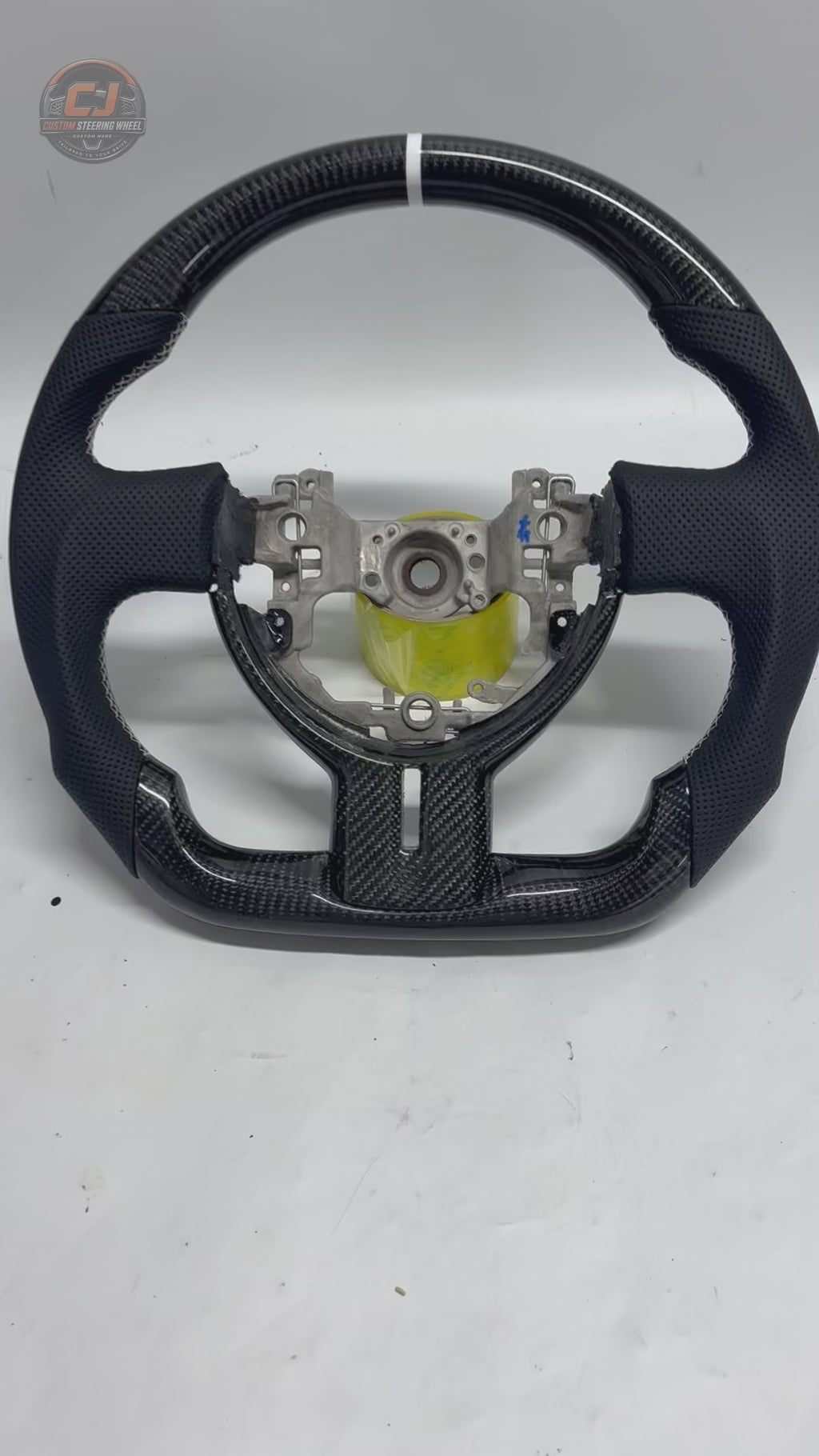 Studio showcase video of Toyota GT86 carbon fiber steering wheel with glossy weave finish, white 12 o’clock stripe, perforated leather grips and custom sport contours by CJ Mod Garage