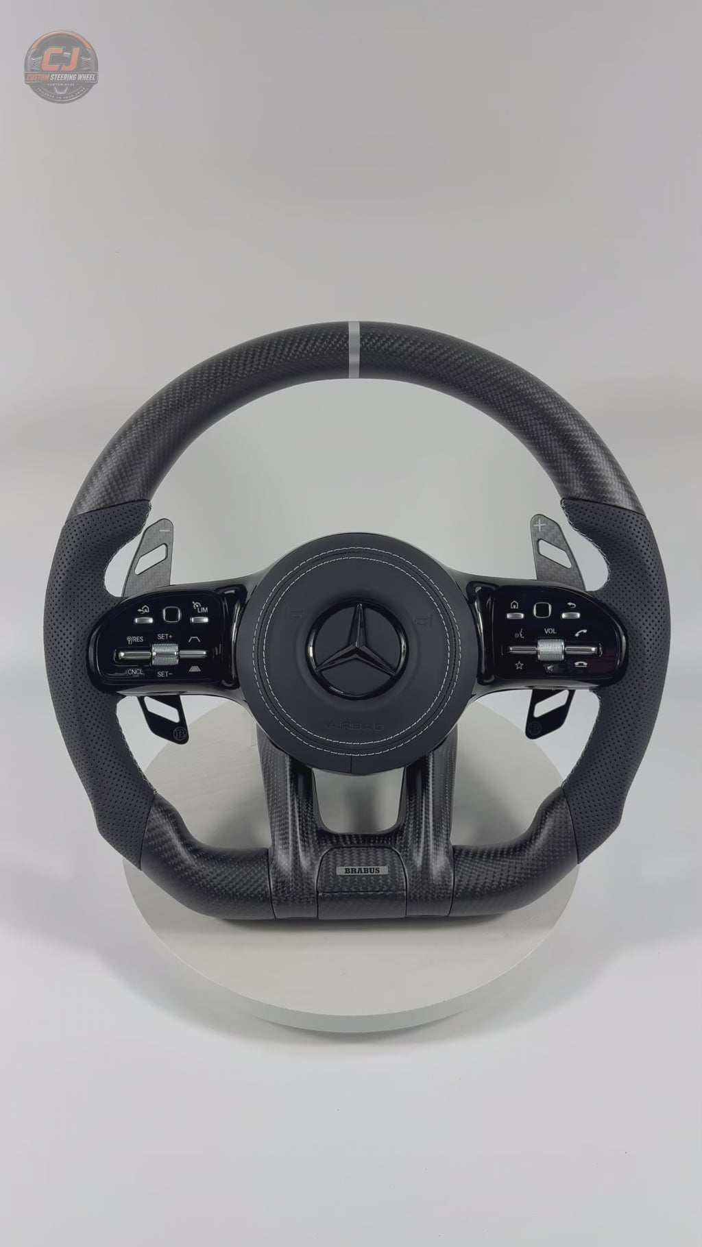 White background video featuring Mercedes AMG matte carbon fiber steering wheel with white center stripe perforated leather grips for W117 W176 W177 W203 W204 W205 W211 W212 W213 W218 C43 C63 C200 C300 CJ Mod Garage