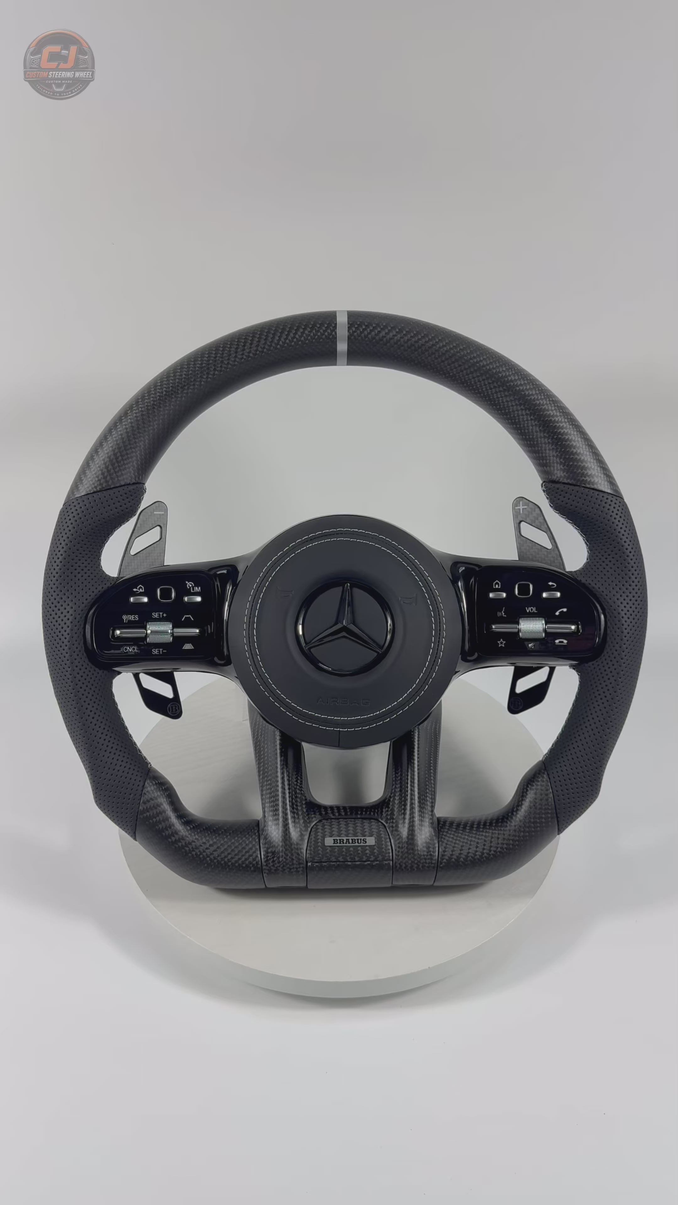White background video featuring Mercedes AMG matte carbon fiber steering wheel with white center stripe perforated leather grips for W117 W176 W177 W203 W204 W205 W211 W212 W213 W218 C43 C63 C200 C300 CJ Mod Garage