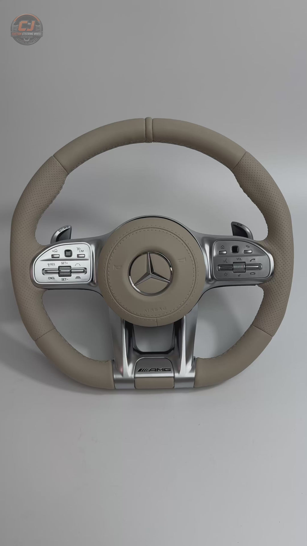 White background video of Mercedes AMG custom beige leather steering wheel with perforated side grips OEM inspired stitching and sporty silver spokes for W117 W176 W177 W203 W204 W205 W211 W212 W213 W218 C43 C63 C200 C300 by CJ Mod Garage