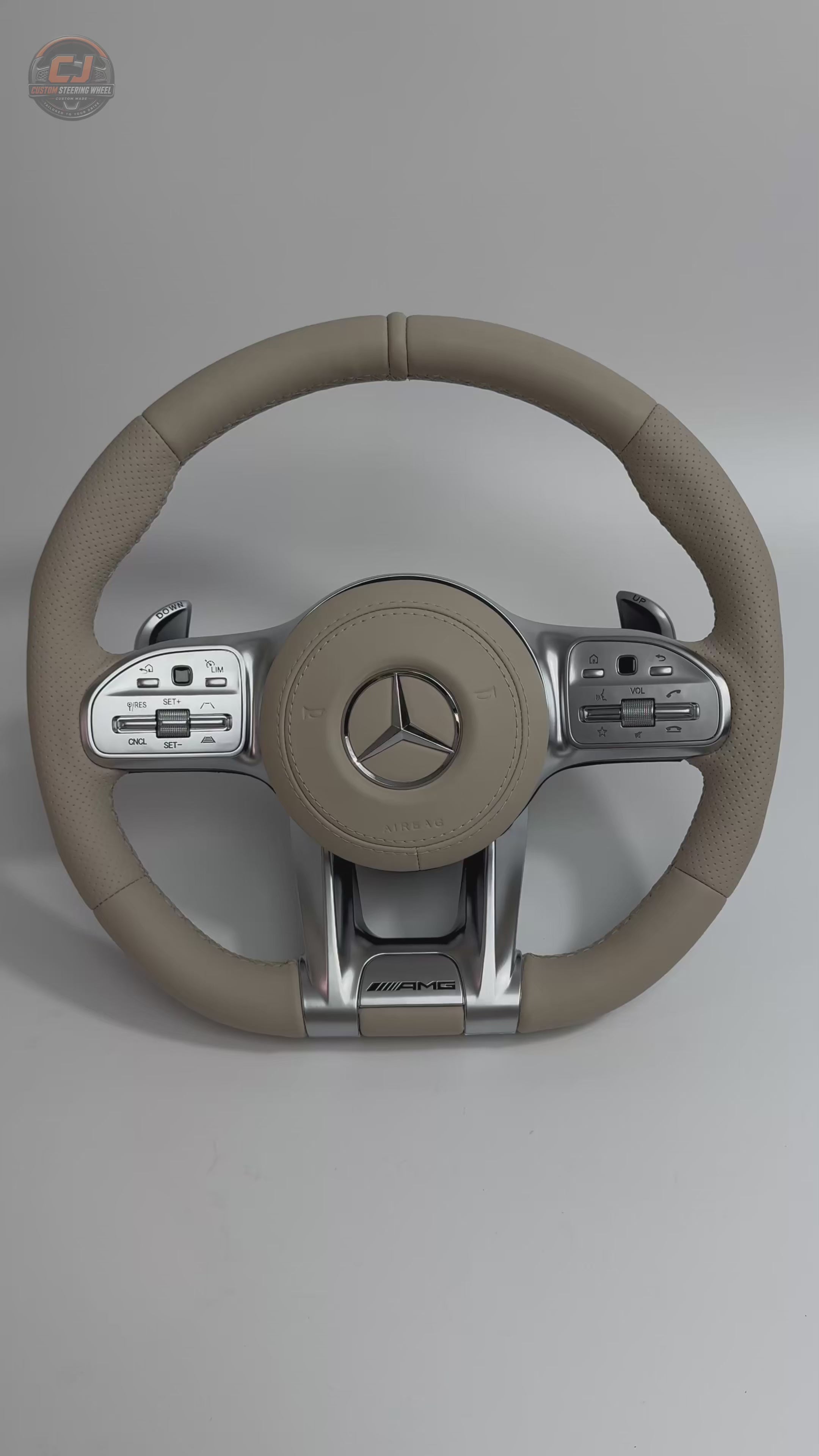 White background video of Mercedes AMG custom beige leather steering wheel with perforated side grips OEM inspired stitching and sporty silver spokes for W117 W176 W177 W203 W204 W205 W211 W212 W213 W218 C43 C63 C200 C300 by CJ Mod Garage