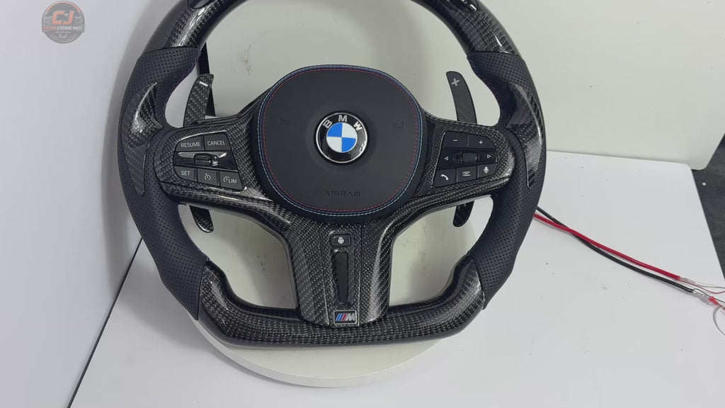 White studio video showing a BMW custom carbon fiber steering wheel with LED shift indicator, digital display, perforated leather grips and carbon paddles for BMW G02 G05 G06 G09 G11 G12 G15 G20 G22 G28 G29 G30 G38 G80 G82 F40 F90 by CJ Mod Garage
