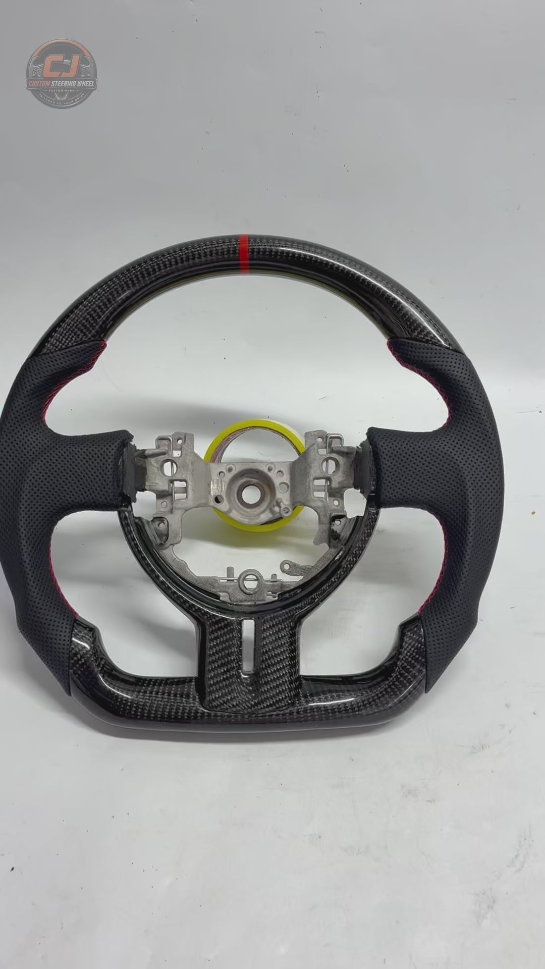 Product showcase video of Toyota GT86 carbon fiber steering wheel with glossy weave finish, perforated leather grips, red contrast stitching and flat-bottom design by CJ Mod Garage
