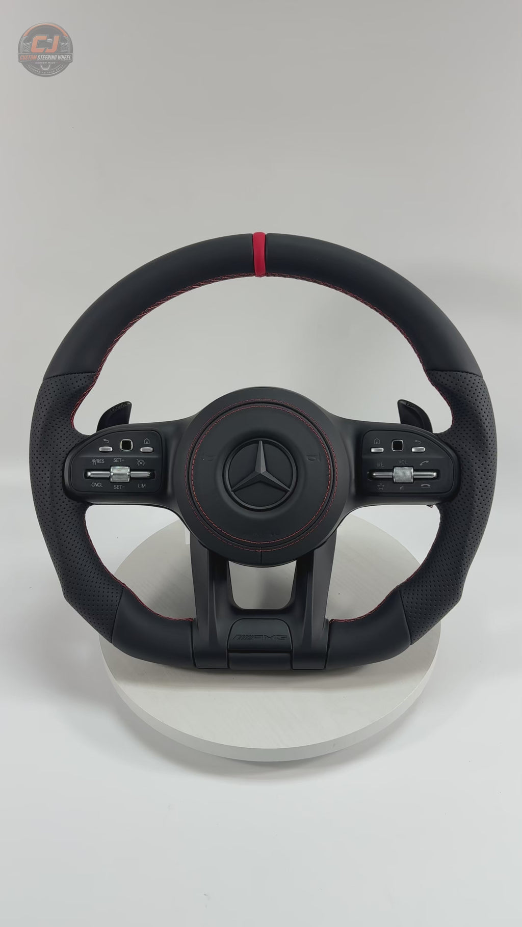 White background Mercedes AMG steering wheel video showing smooth black leather red center stripe perforated side grips for W117 W176 W177 W203 W204 W205 W211 W212 W213 W218 C43 C63 C200 C300 CJ Mod Garage