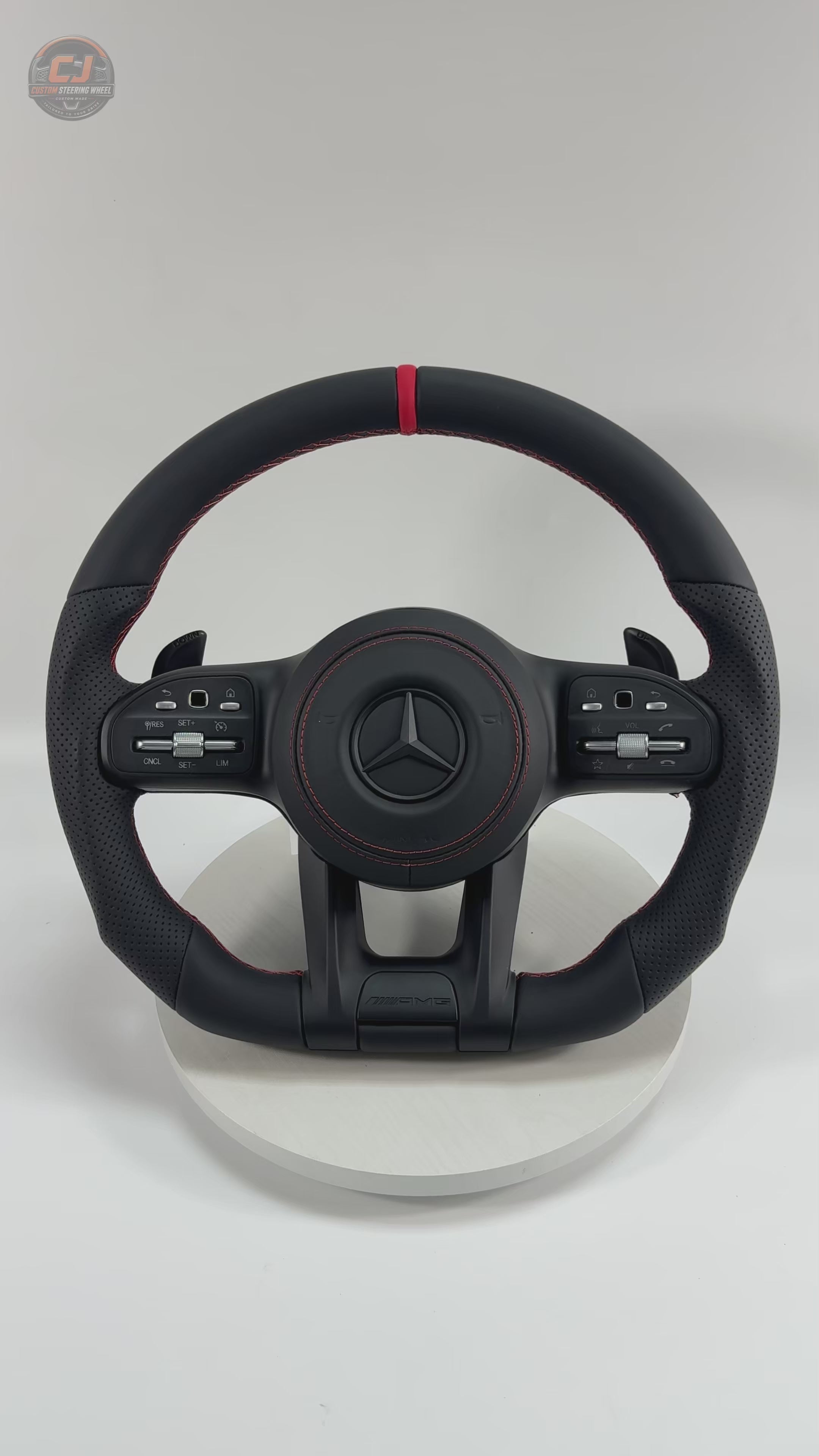 White background Mercedes AMG steering wheel video showing smooth black leather red center stripe perforated side grips for W117 W176 W177 W203 W204 W205 W211 W212 W213 W218 C43 C63 C200 C300 CJ Mod Garage