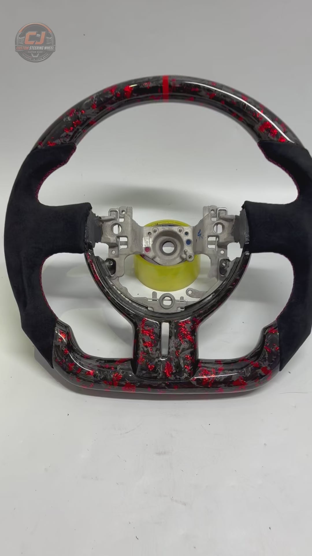 360-degree studio video of Toyota GT86 forged carbon fiber steering wheel with red flake finish, Alcantara grip sections, red 12 o’clock stripe and handcrafted sport design by CJ Mod Garage