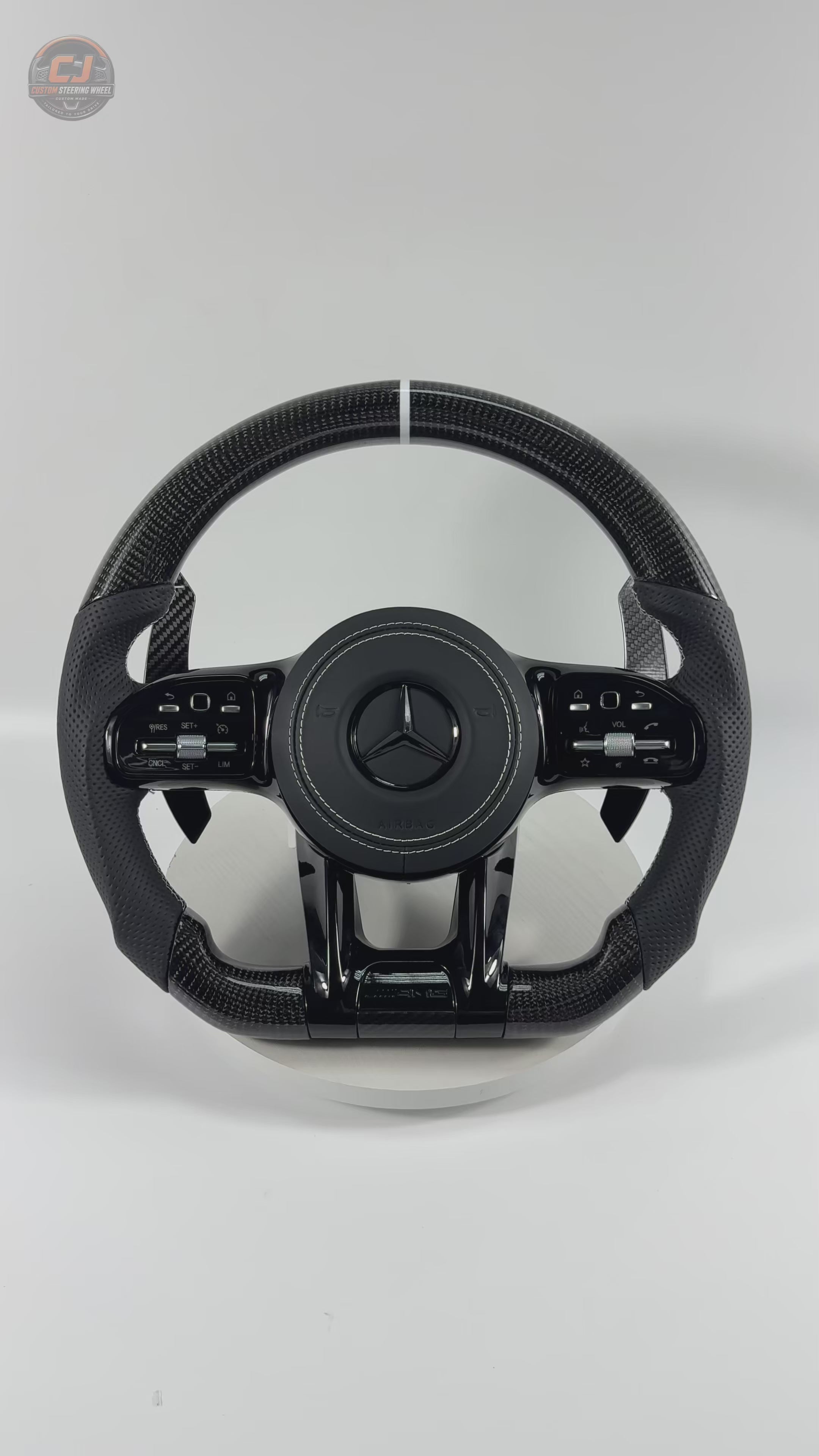 White background video featuring Mercedes AMG carbon fiber steering wheel with white twelve clock stripe black leather grips carbon paddle shifters for W117 W176 W177 W203 W204 W205 W211 W212 W213 W218 C43 C63 C200 C300 CJ Mod Garage