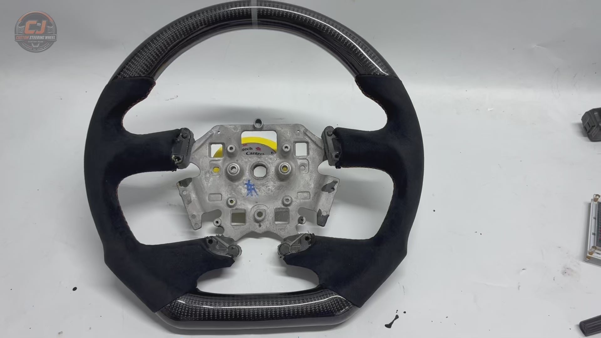 White background product video of Ford Falcon FG XR XR6 XR8 custom steering wheel in carbon fiber black suede grips and orange stitching by CJ Mod Garage