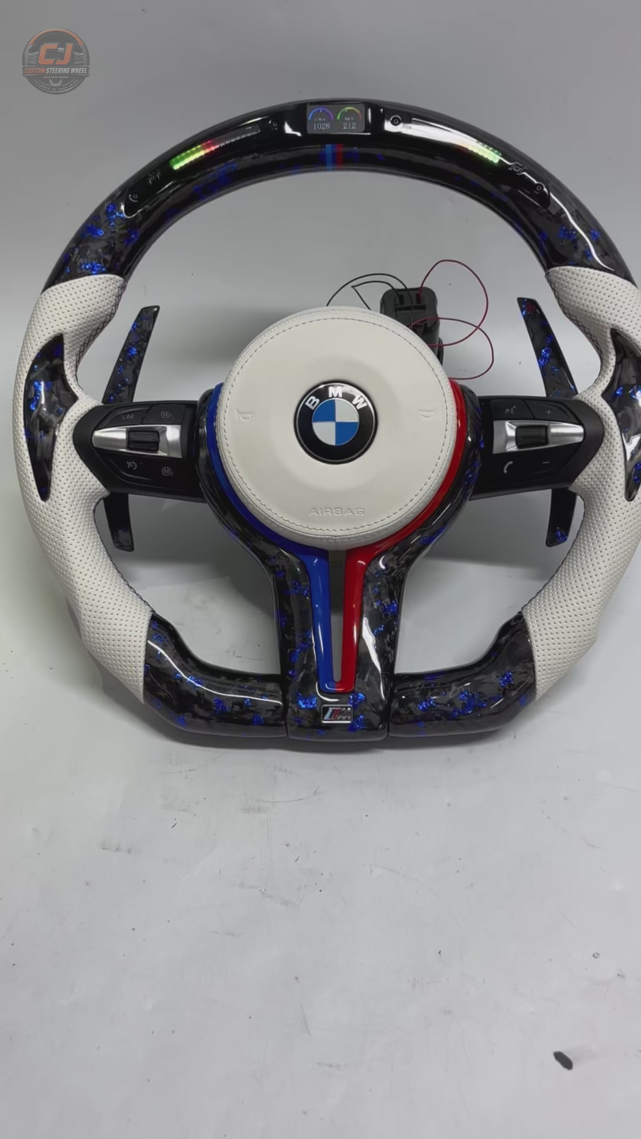 360-degree showcase video of custom BMW F Series E90 E92 E93 forged carbon fiber steering wheel featuring white perforated leather, blue forged carbon accents, LED shift lights, multifunction buttons, and carbon paddle shifters