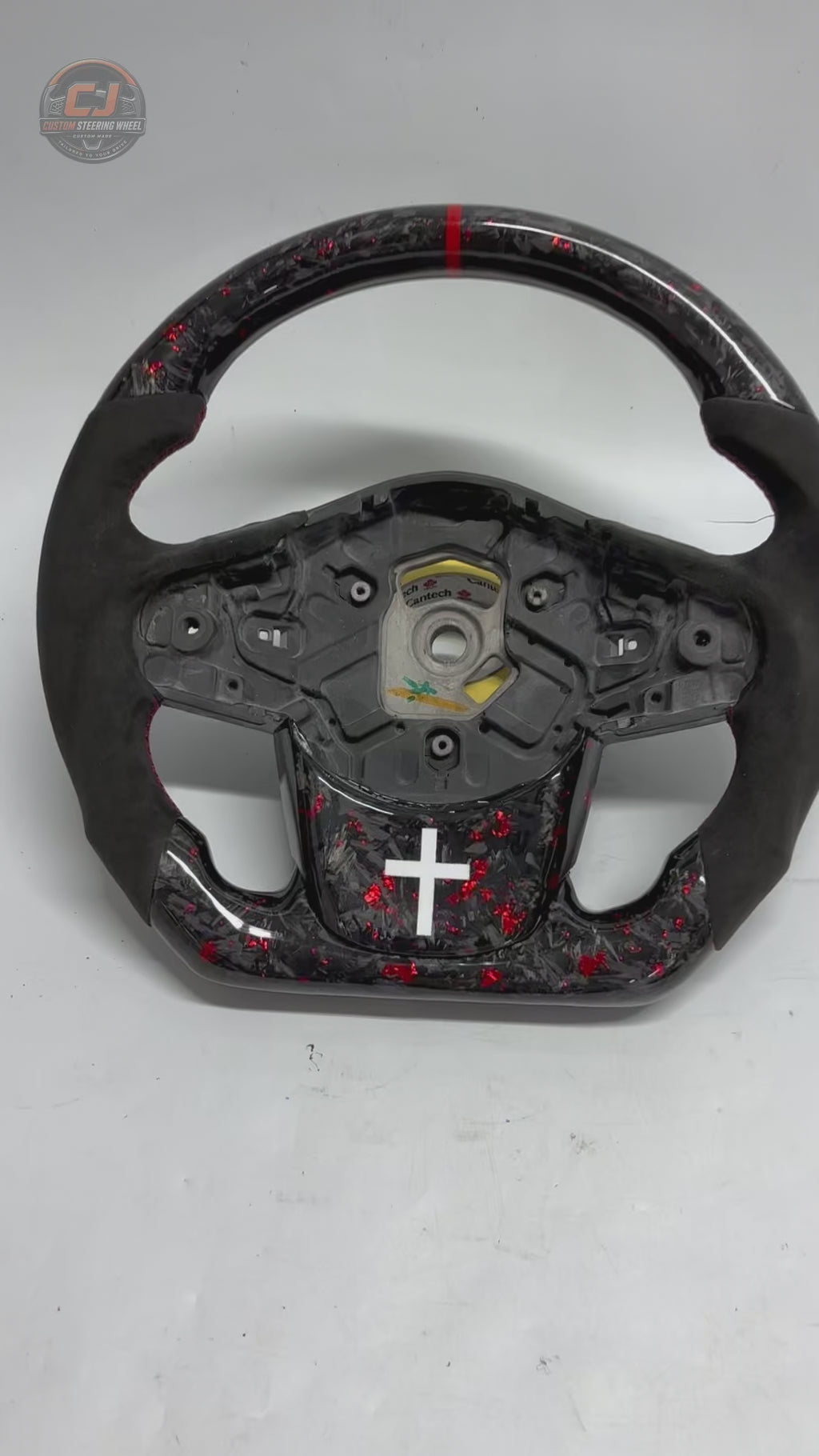 Studio showcase video of Toyota GR Supra A90 A91 forged carbon steering wheel with red flake carbon fiber, Alcantara grip sections, flat-bottom profile and custom detailing by CJ Mod Garage