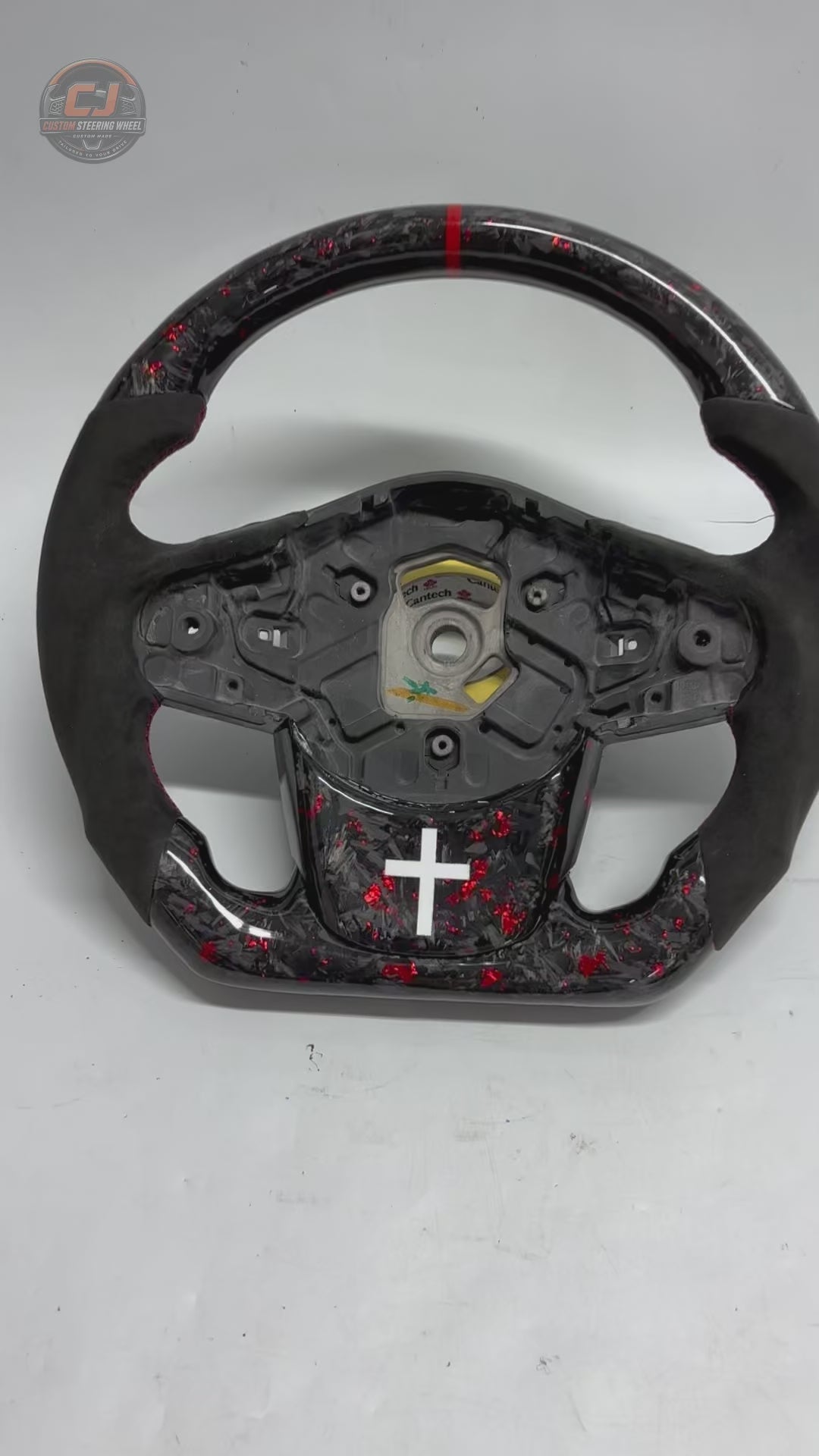 Studio showcase video of Toyota GR Supra A90 A91 forged carbon steering wheel with red flake carbon fiber, Alcantara grip sections, flat-bottom profile and custom detailing by CJ Mod Garage